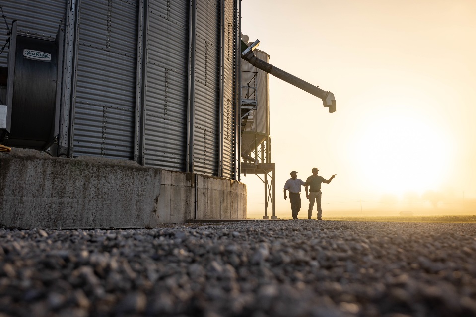 Farm Credit Mid-America crop insurance agent walks with customer by grain bin