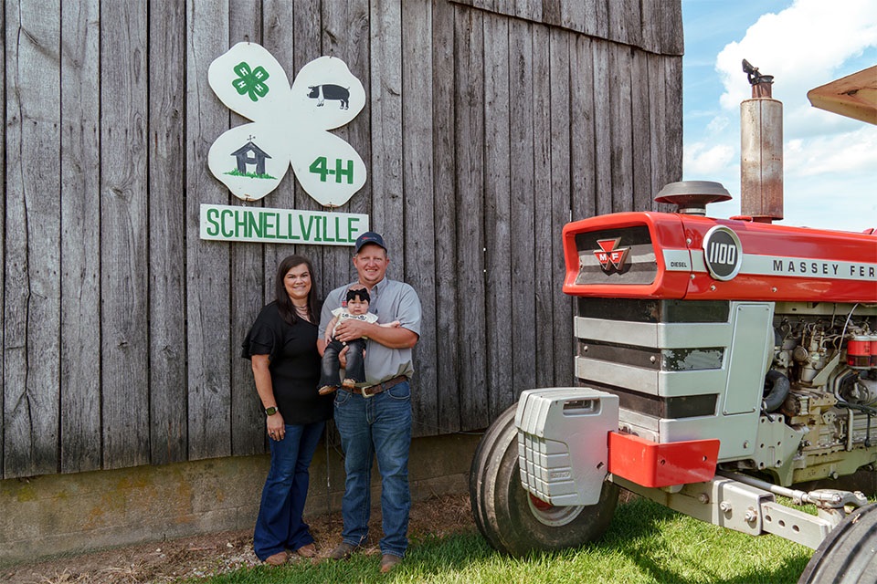 Farm Credit Mid-America customer-owners stand in front of tractor on their farm.