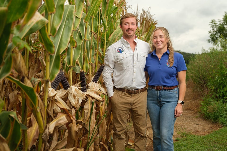 Clate and Mindy Jones stand next to a corn field financed by Farm Credit Mid-America.
