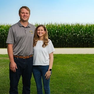 Josh and Kate Pottschmidt stand in front of popcorn field financed through Farm Credit Mid-America