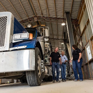 Customers discuss leasing program with Farm Credit Mid-America Financial Officer.