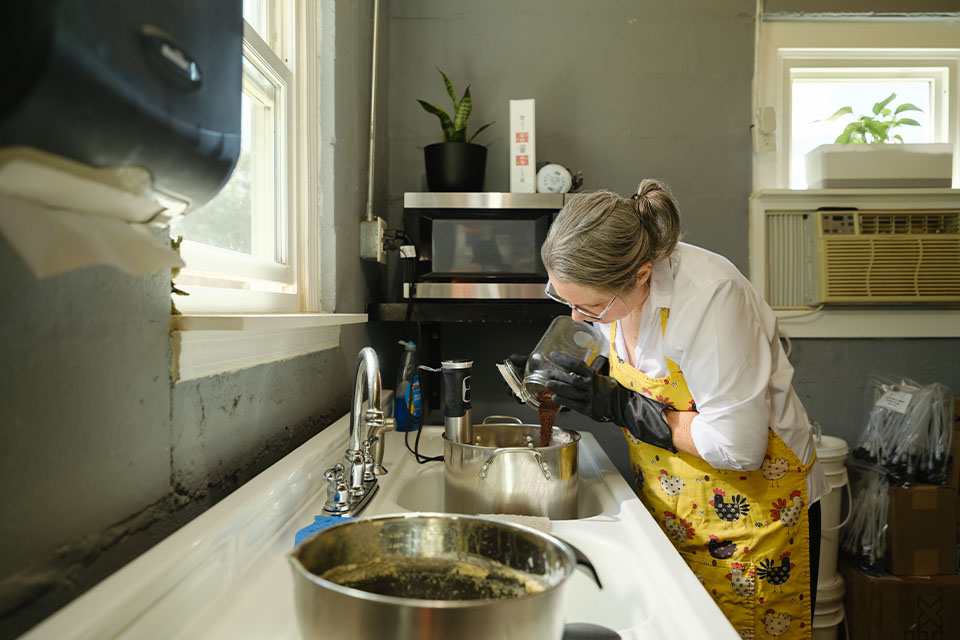 Rural 1st customer Suzanne Harper mixes a batch of soap for Farm Credit Mid-America team members.
