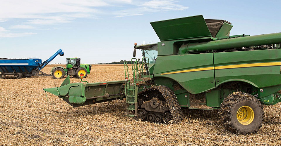 Combine and tractor funded through ag equipment financing by Farm Credit Mid-America.