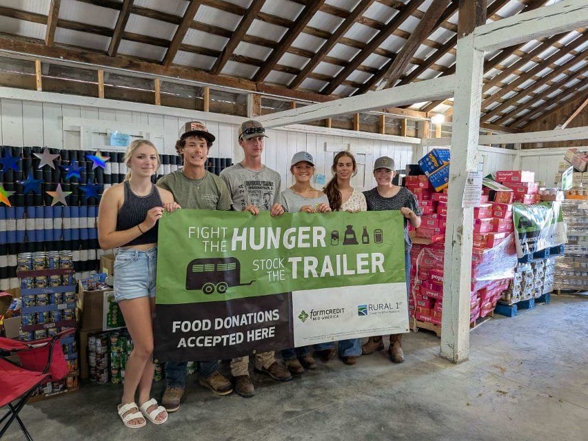 4-Hers holding a Fight the Hunger, Stock the Trailer banner in Jackson County, IN