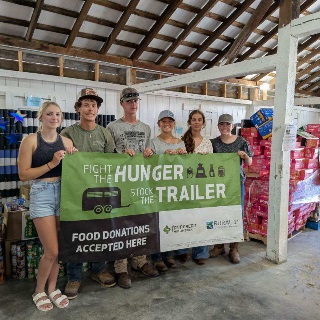 4-Hers holding a Fight the Hunger, Stock the Trailer banner in Jackson County, IN