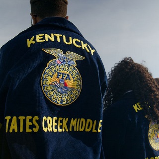A line of students wear FFA jackets with Tates Creek Middle printed on the back of them.