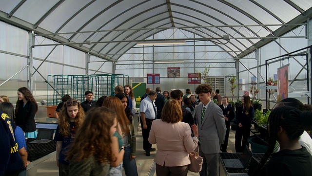 Students and adults mill around inside the new greenhouse at Tates Creek Middle School in Kentucky.