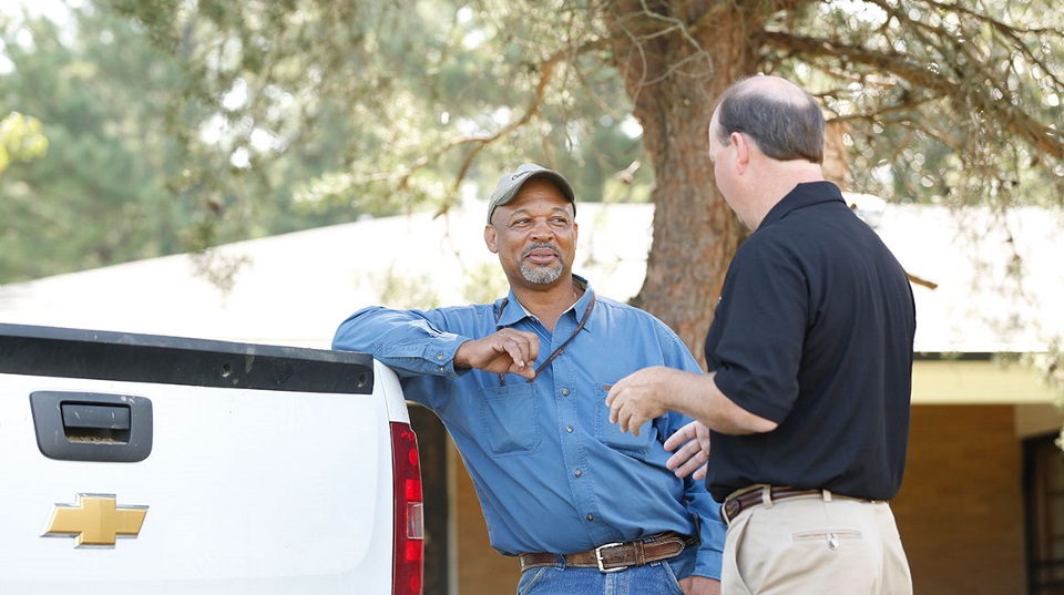 Two men talking by a truck.