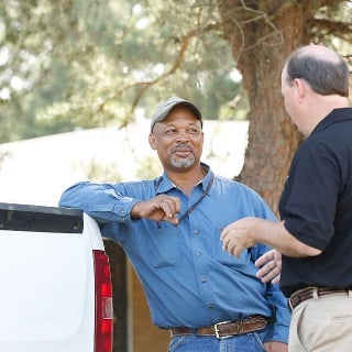 Two men talking by a truck.