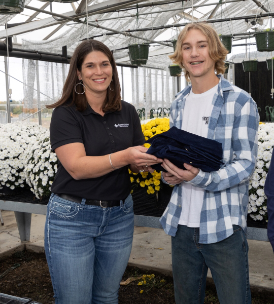 Team member presents FFA jacket to student