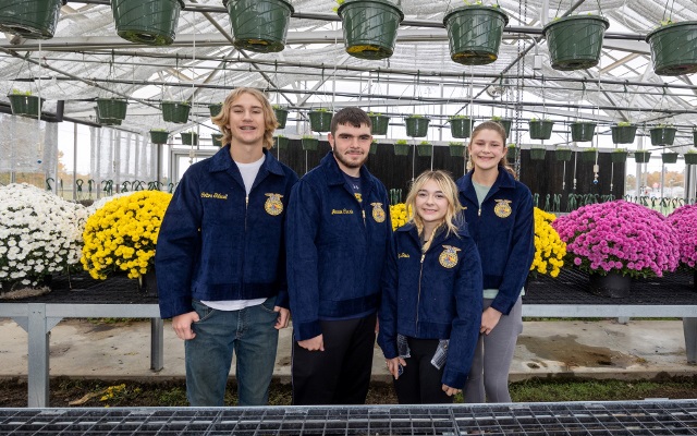 FFA students stand in greenhouse