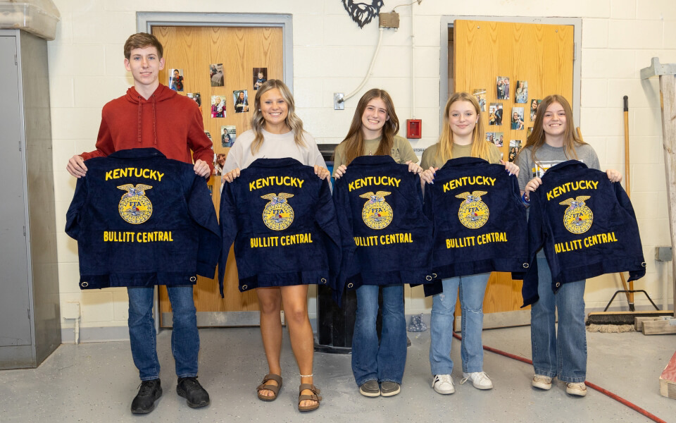 FFA students stand holding jackets