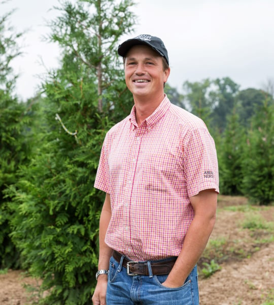 Man standing in front of trees.