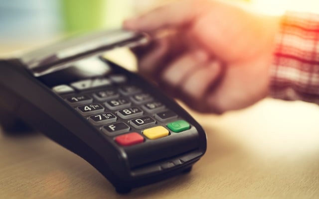 Farmer uses a credit card machine.