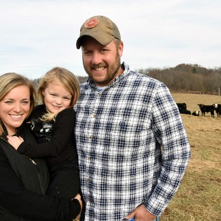 Family stands in a cattle field.