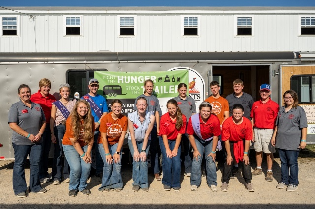 4-Hers stand in front of a trailer full of donated food