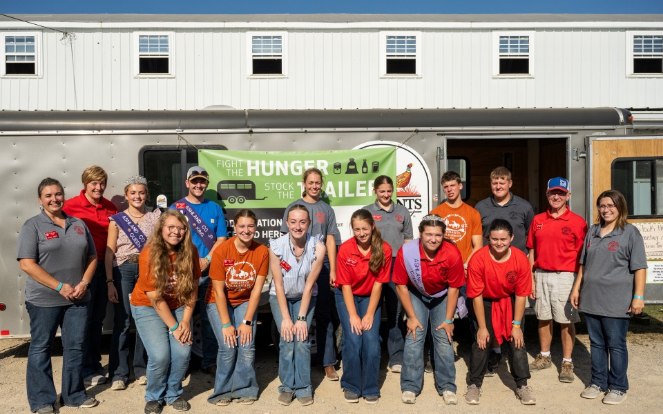 4-Hers grouped in front of a trailer of donated food