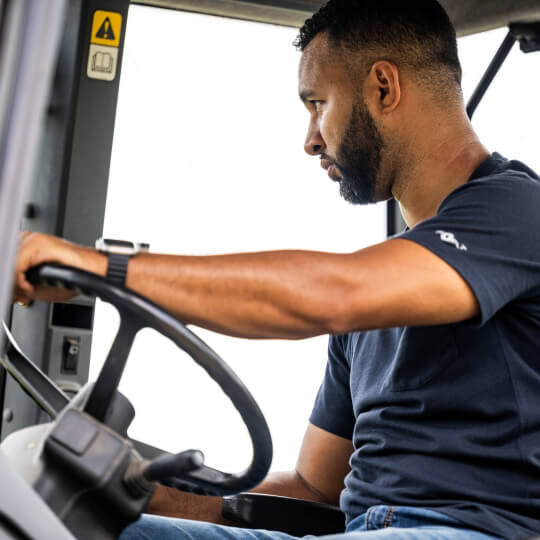 Farmer inside tractor cab eligible for tractor financing and equipment loans