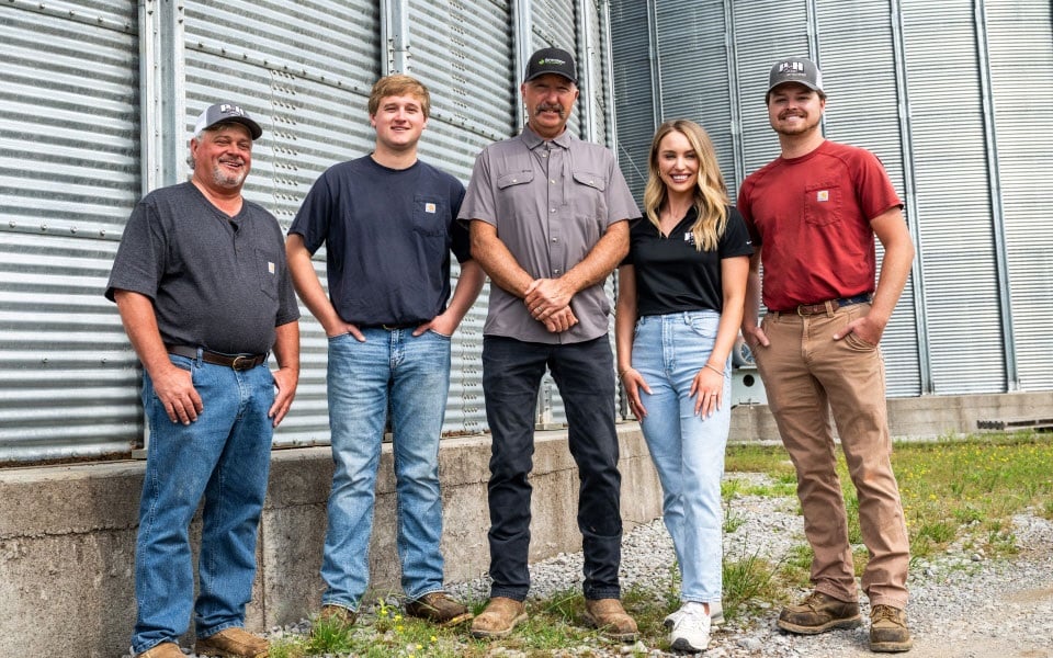 Parish and Hooks families stand in front of their grain bins financed by Farm Credit Mid-America