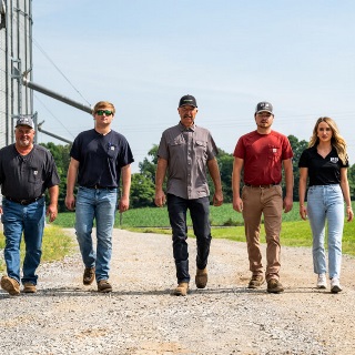 Multigenerational farmers walking by grain bins