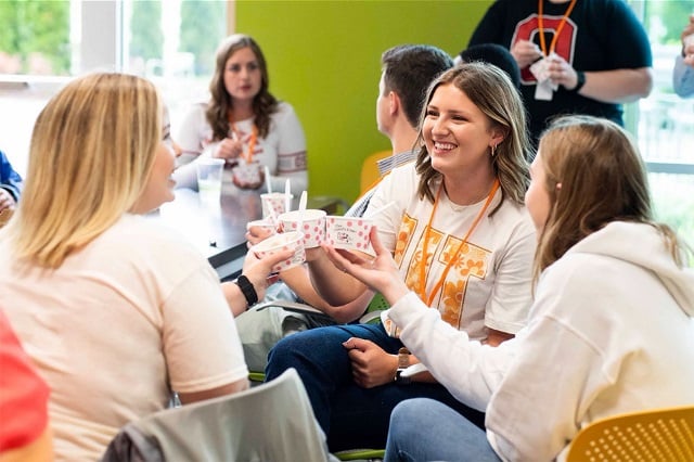 Students in a Farm Credit Mid-America Scholars cohort tap their cups of ice cream together as a toast.
