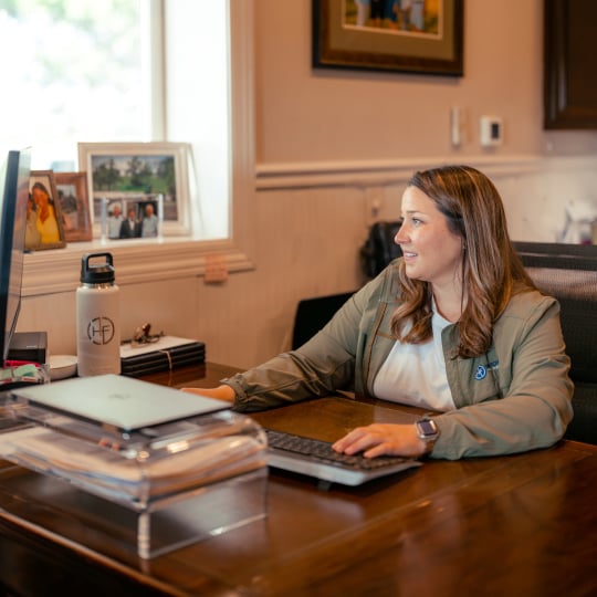 Woman completing her farm balance sheet at a desk in her office