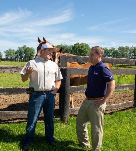 Customer and loan officer talk about Loan Conversion options in front of horse pasture