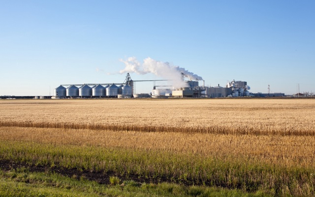Large ethanol plant with a field in the foreground.