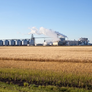 Large ethanol plant with a field in the foreground.