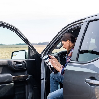 Woman checks her tablet in a truck.