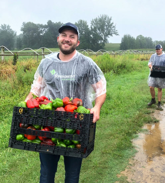Man carrying basket of peppers.