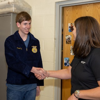 Farm Credit Mid-America team member presents new FFA jacket to student