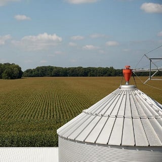 Elevated view of crop field and grain silo.