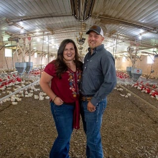 Couple standing in broiler house.